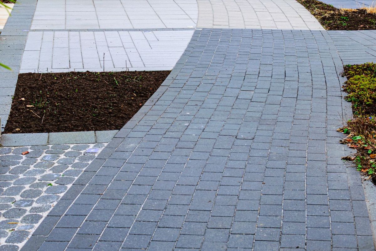 Gebogen tuinpad van klinkers langs een border
