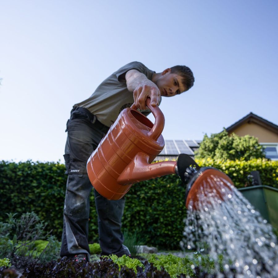 Hovenier geeft water in een tuin